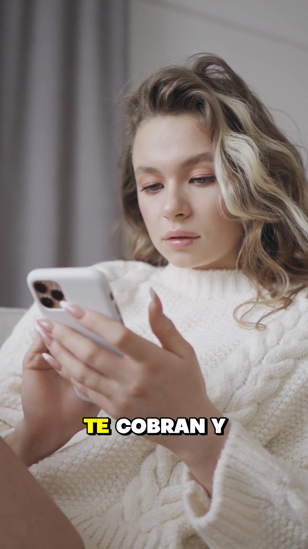 Mujer mirando su celular al inicio del video sobre cobros de apps